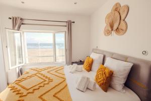 a bedroom with a bed with a view of the beach at HOTEL RESTAURANT LA COTE REVEE in Leucate