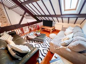a living room with a leather couch and a table at 3 Bed in Holt oc-1331 in Bodham