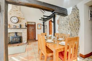a dining room with a wooden table and a fireplace at 3 Bed in Holt oc-1331 in Bodham