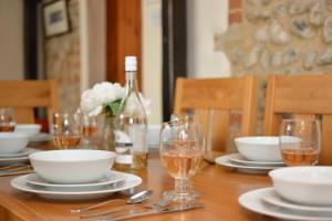 a table with plates and bowls and a bottle of wine at 3 Bed in Holt oc-1331 in Bodham +12 photos