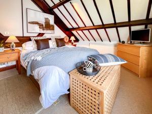 a bedroom with a bed and a table with a television at 3 Bed in Holt oc-1331 in Bodham