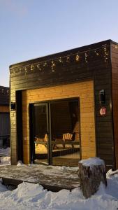 a small cabin with a deck in the snow at Arrow Burabay in Borovoye