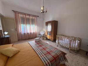 a bedroom with a bed and a chair and a window at Casa Vacanze Nonna Mena in Fontechiari