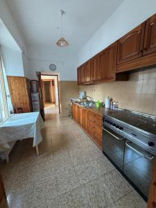 a kitchen with wooden cabinets and a stove top oven at Casa Vacanze Nonna Mena in Fontechiari