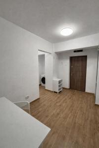 an empty room with a wooden floor and a door at Ultracentral Modern Apartment Toma Caragiu, Ploiesti in Ploieşti