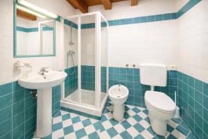 a bathroom with a toilet and a sink and a shower at Aurisina heart apartment in Aurisina +1 photo