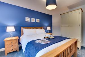 a bedroom with a large bed with a blue wall at 5 Bed in Fryup Dale oc-wa291 in Danby