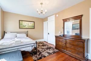 a bedroom with a large bed and a dresser at Candlelight Chamber - Private Room with Shared Space in Chester