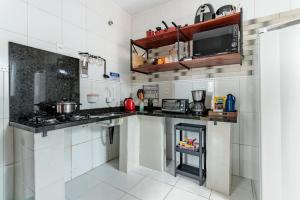 a kitchen with white cabinets and a stove at Casa perto do centro e da Udesc Cefid in Florianópolis