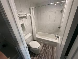 a small bathroom with a toilet and a sink at Crescent Motel, South Gate - Los Angeles in South Gate