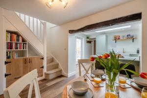 a kitchen and dining room with a table with flowers at 2 Bed in Aylsham oc-s30931 in Aylsham