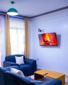 a living room with a blue couch and a table at Tataji Suites in Kisii