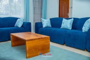 a living room with a blue couch and a coffee table at Tataji Suites in Kisii
