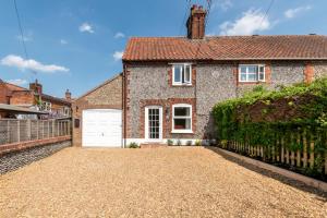 a brick house with a white garage at 2 Bed in Aylsham oc-s30931 in Aylsham