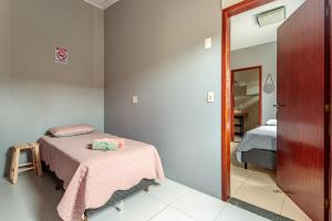 a bedroom with a bed with a pink blanket at Casa perto do centro e da Udesc Cefid in Florianópolis