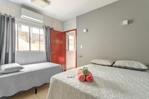 two beds in a room with two pink towels on them at Casa perto do centro e da Udesc Cefid in Florianópolis