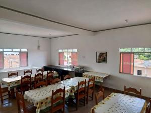a dining room with tables and chairs and windows at China Hotel in Canindé de São Francisco