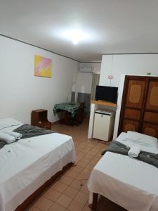 a hotel room with two beds and a television at China Hotel in Canindé de São Francisco