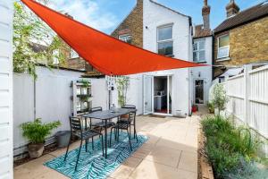 a patio with a table and chairs and a red umbrella at 2 Bed in Whitstable oc-w31887 in Whitstable