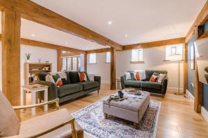 a living room with two couches and a table at 4 Bed in Etloe oc-e34026 in Awre
