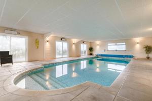 a large swimming pool in a large room with windows at 4 Bed in Etloe oc-e34026 in Awre