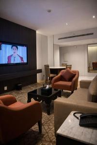 a living room with couches and a flat screen tv at LeChateau Boutique Hotel in Jeddah