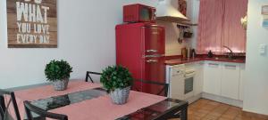 a kitchen with a table and a red refrigerator at El Huerto de Pipo in Navarredonda de Gredos