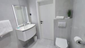 a white bathroom with a sink and a toilet at Nin Heritage Home in Nin