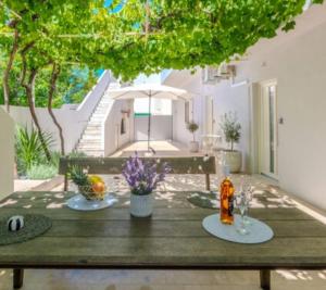 a wooden table with flowers on top of a patio at Nin Heritage Home in Nin