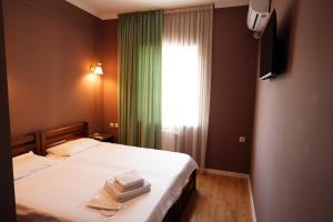 a bedroom with a bed with two towels on it at Hotel Maisis Ezo in Kutaisi