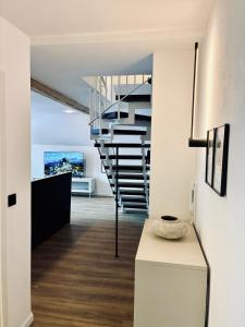 a spiral staircase in a room with white walls and wooden floors at LYMA Suites - Apartment B44 in Immenstadt im Allgäu