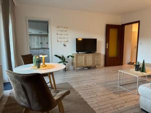 a living room with a table and a tv at Sweet Escape in Bad Pyrmont