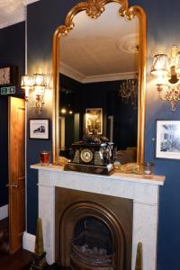 a fireplace with a mirror and a clock on it at The Southbank Torquay by the sea in Torquay +131 photos