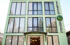 a green building with a sign on it at Hotel Maisis Ezo in Kutaisi