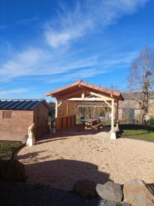 a wooden pavilion with a picnic table and a shed at O Gîte d'anthony in Talizat