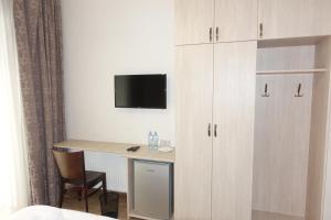 a room with a desk and a tv on a wall at Metekhi Stay - Old Tbilisi in Tbilisi City