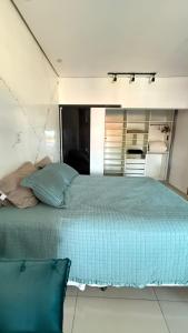 a bedroom with a bed with a blue comforter at Flat Zona Sul in Teresina