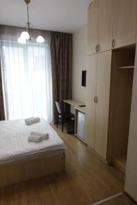 a bedroom with a bed and a desk and a window at Metekhi Stay - Old Tbilisi in Tbilisi City