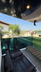 a balcony with two chairs and a swimming pool at Flat Zona Sul in Teresina