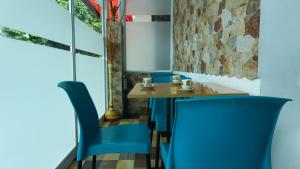 a table and two blue chairs in a restaurant at Hotel Royal Classy in Villavicencio