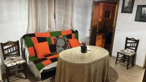 a living room with a couch and a table with chairs at Casa para parejas El Cerrillo in Castril