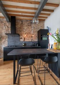 a kitchen with a large black table and chairs at Number 9 holiday apartments in Middelburg