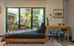 a bedroom with a bed with stools and a table at Whisper Oasis - Award-Winning Private Jacuzzi Pool Villa - 3BR, Daily Service in Chiang Mai