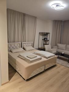 a white bedroom with a bed and a couch at Marlin City Apartment Erdgeschoss 1 in Bielefeld