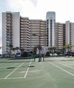 two tennis courts in front of a large building at Phoenix East 808 in Orange Beach