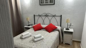 a bedroom with a bed with two red pillows at Casa para parejas El Cerrillo in Castril