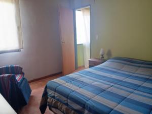 a bedroom with a blue bed and a window at Casa Boreal dptos estilo casa in Puerto Madryn