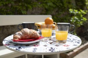 a table with a plate of bread and two glasses of orange juice at Casa Alfonso in Minori