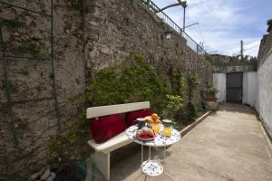a bench with a table with food on it at Casa Alfonso in Minori +11 photos