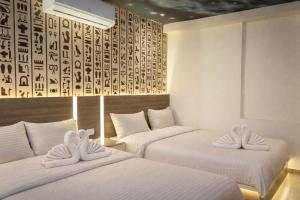 two beds in a hotel room with towels on them at Narmer Pyramids View in Cairo